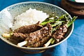 Seared Beef Wrapped Asparagus Spears in a Bowl with White Rice
