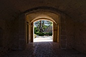 Einfahrt mit alter Gewölbedecke und Blick in Garten