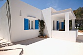 Mediterranean apartment block architecture with blue shutters below a sunny sky