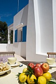 Breakfast table with fresh fruit on Mediterranean terrace of apartment building