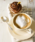 Eine Tasse Cappuccino mit Schokoladen-Cupcake