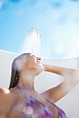 Woman in bikini showering outdoors