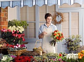 Florist mit Blumenstrauss im Laden