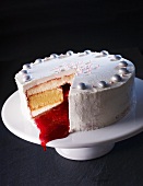 Schneewittchentorte, white glazed sponge cake with cream and red fruit sauce