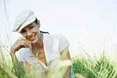 Woman in field holding up flower