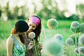 Young hippie women looking at allium flower