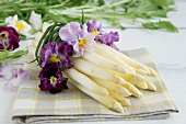 A bunch of white asparagus tied with pansies