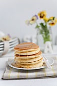 A stack of pancakes filled with vanilla cream and maple syrup