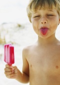Little boy with popsicle, sticking tongue out with eyes closed