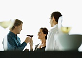 Zwei Männer und eine Frau bei einer Cocktailparty