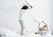 Boys having pillow fight on bed