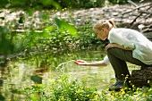 Young woman splashing water by river