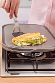 A green asparagus and feta cheese omelette on a hot stone