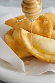 Ricotta pockets being drizzled with honey