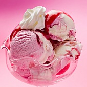 Raspberry and vanilla ice cream with raspberry sauce and cream (close-up)
