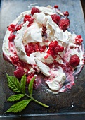 Meringue with raspberries on a baking tray