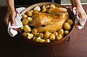 Stuffed Roast chicken with liquorice in a roasting tin