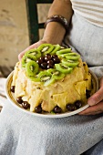 A woman holding a lemon charlotte