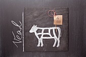 A sketch of a calf and an English label on a chalkboard