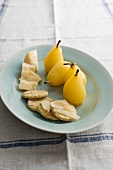 A poached pear with oat biscuits and Parmesan cheese