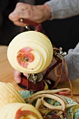 An apple being peeled with a machine