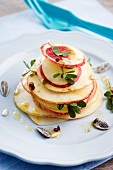 A nectarine and cheese tower with sunflower seeds