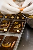 Preparing bars of chocolate with candied fruits and nuts