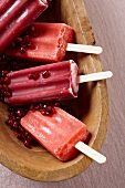 Pomegranate Popsicles in a Wooden Bowl with Pomegranate Seeds