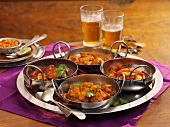Four different types of curries on a tray