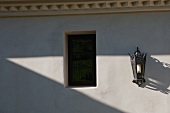 Venezianisch anmutende Wandlaterne neben Fensteröffnung in Hausfassade