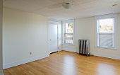 Empty room in apartment with hardwood floor and heater