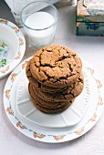 A Stack of Molasses Cookies on a Plate with a Glass of Milk