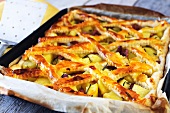 A lattice potato and ham pie on a baking tray