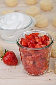 Kleingeschnittene Erdbeeren, Quarkcreme und Kuchen (Zutaten für Push Up Cake Pops)