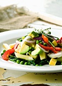 Pasta and vegetable salad with avocado, spinach, peas and cheese