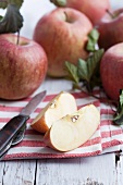 Apple wedges on a cloth with whole apples in the background