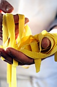 A chef holding homemade tagliatelle