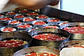 Unbaked tomato focaccia in baking tins