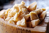 Pieces of Parmesan cheese in a hollowed out wedge of Parmesan