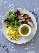 Grilled chicken breast with olive oil, couscous and a mixed leaf salad