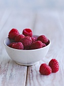 Fresh Raspberries on Napkins in Grass; Picnic Basket