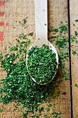 Dried parsley on a wooden spoon