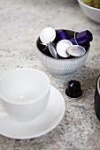 An espresso cup and coffee capsules