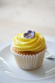 A lemon cupcake decorated with a sugar flower