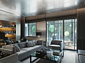 Eleganter Wohnraum mit Terrassentüren und helle Polstergarnitur vor Couchtisch in klassisch modernem Stil