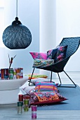 Basketwork armchair, ethnic cushions, Oriental glasses, designer pendant lamp and coffee table