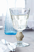 Weinglas mit Seil dekoriert am Stiel