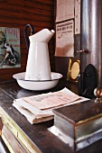 Alter Waschkrug mit Schüssel auf Vintage Küchenherd