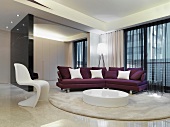 Eleganter Wohnraum mit Klassikerstuhl und modernem Sofa in Violett vor rundem Bodenmöbel auf Teppich