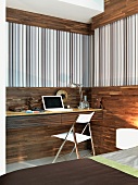 Office corner - fitted desk against half-height wood panelling and striped wallpaper below wooden frieze